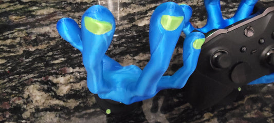 Alien hand holding a game controller