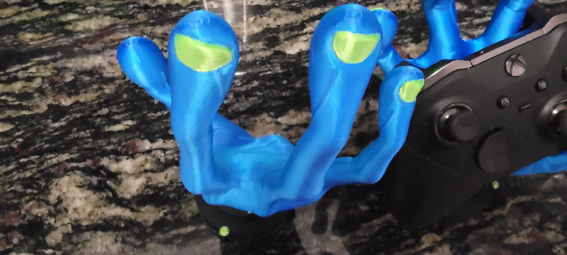 Alien hand holding a game controller