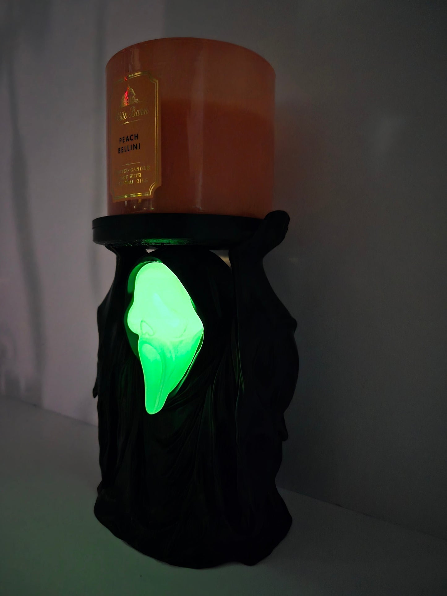 Angled view of the phantom candle holder glowing green in the dark