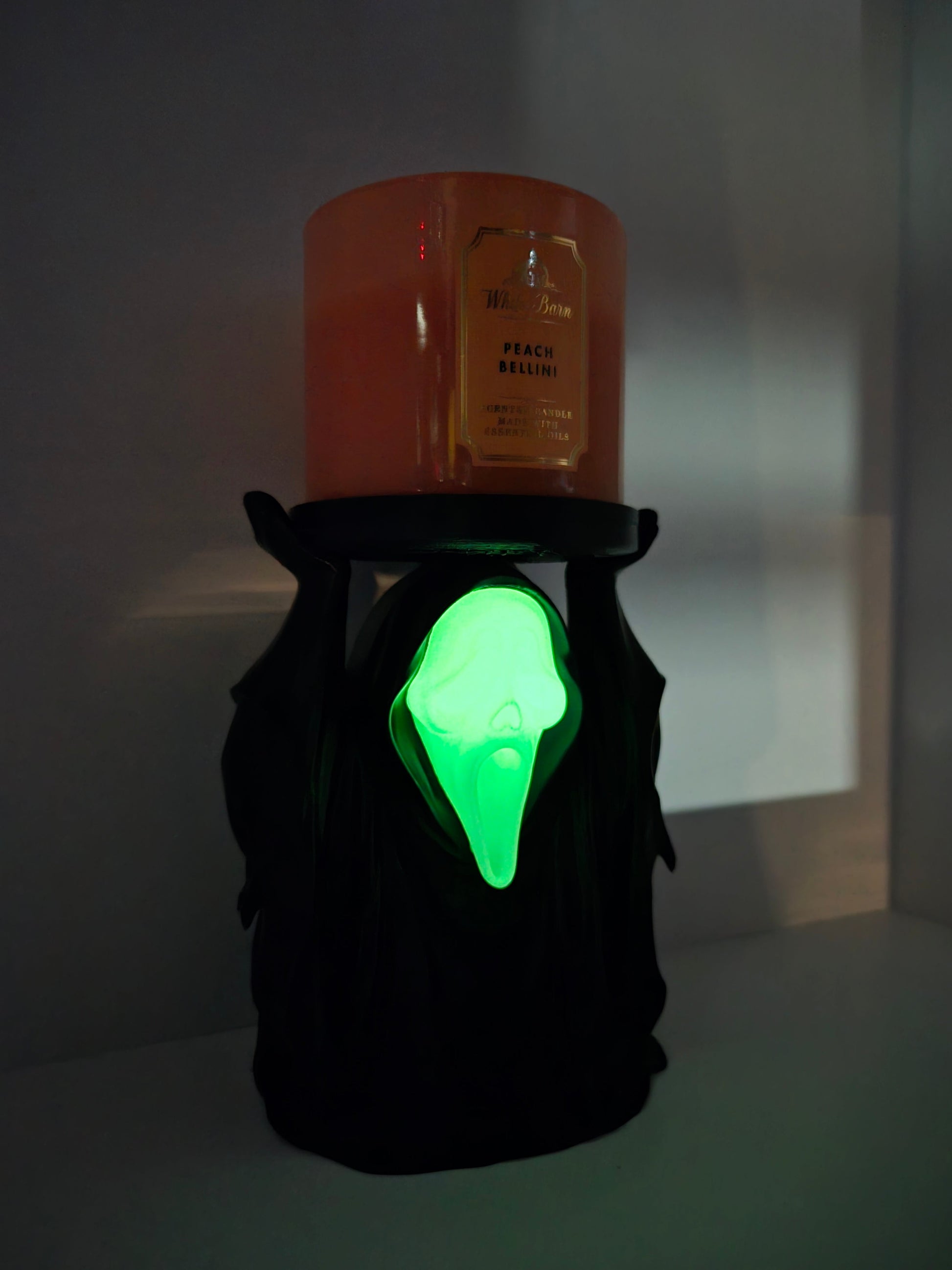 Glow-in-the-dark face lit green in a dim room