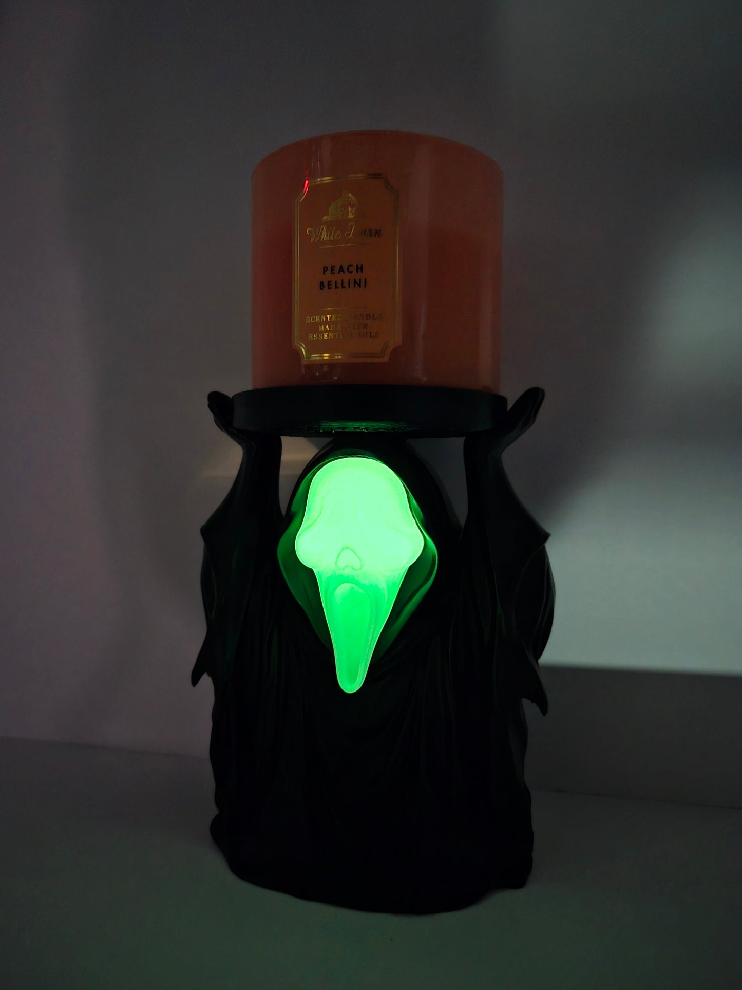 Phantom candle holder glowing green in the dark, front view